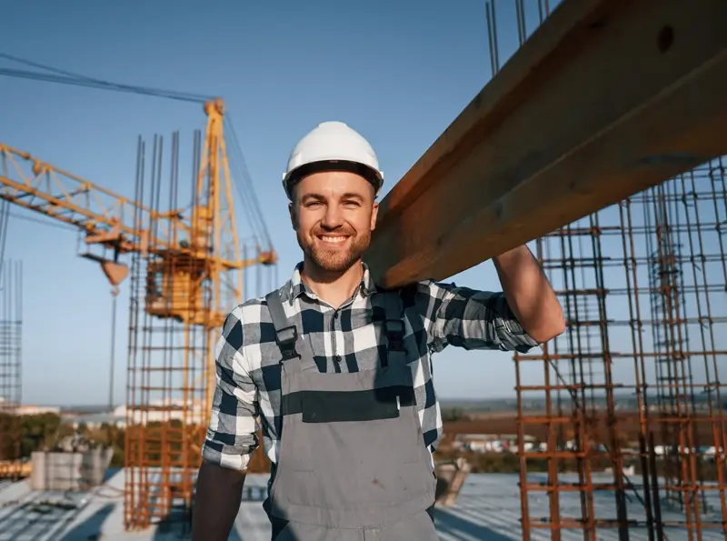 View of a construction housing site with workers building a roof and wall and two women recruiters in the corner