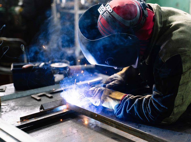 Man using welder to join/weld steel together