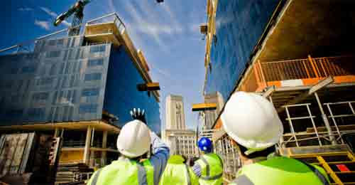 Skyscrapers in construction with workers in high vis pointing at construction works