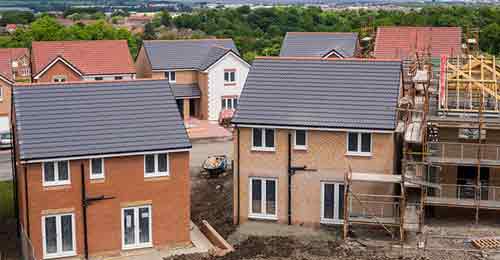 Housing Construction site showing 2 near finshed homes made with brick