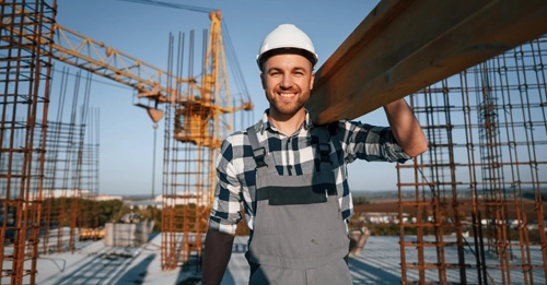 View of a construction housing site with workers building a roof and wall and two women recruiters in the corner