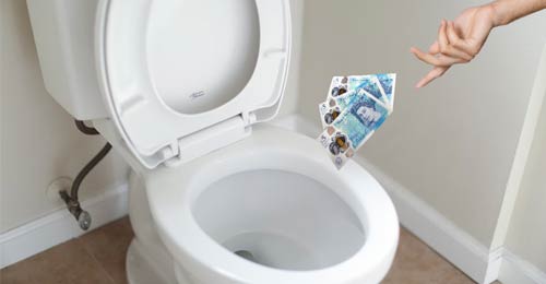 Image of a toilet with five pound notes being dropped into the toilet by someones hand.