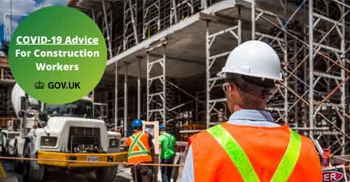 Construction site with a construction worker in a high vis showing a covid-19 badge for construction workers advice