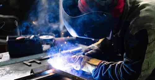 Man using welder to join/weld steel together