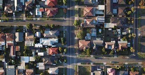 Overhead view of a neighbourhood with many houses of different shapes and sizes.