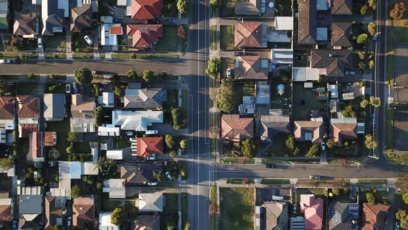 Overhead view of a neighbourhood with many houses of different shapes and sizes.