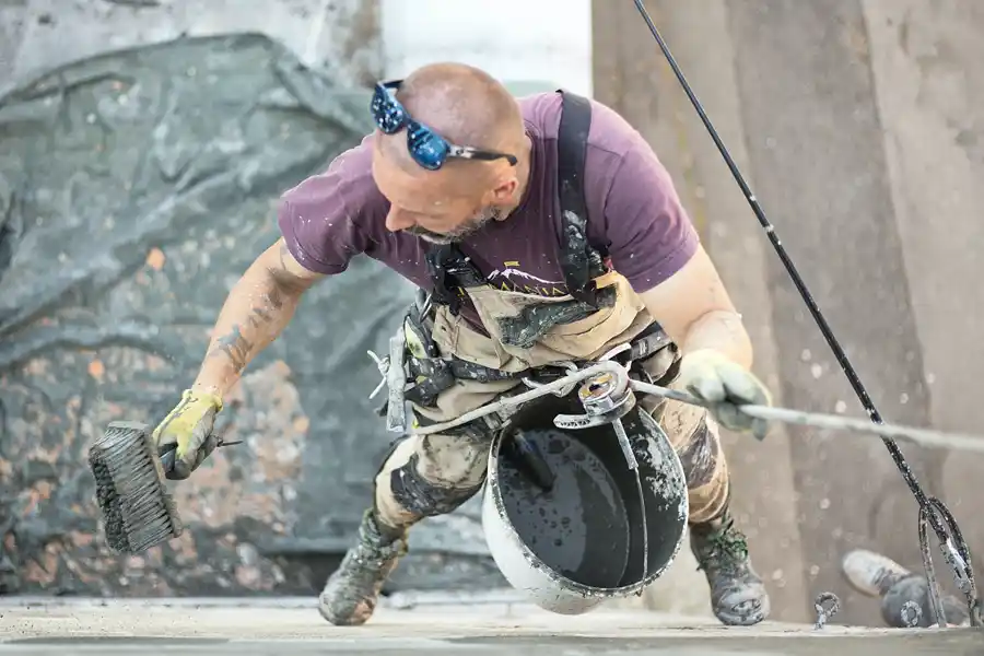 Construction worker at heights on a shipping container clipped in to a safety harness