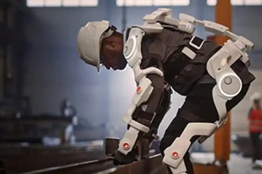 Construction worker with an exo suit to assist in lifting heavy steel and white hard hat on