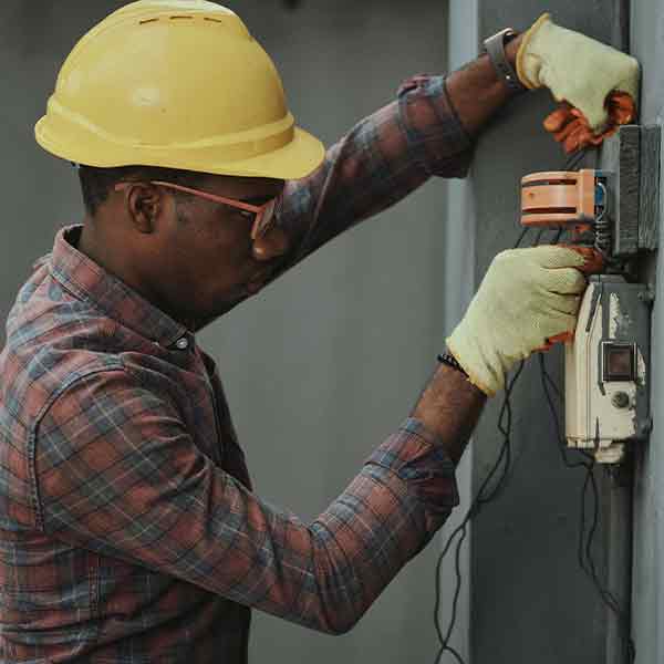 A square image showing a Electrician at work