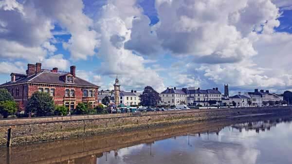 A cloudy view of Barnstaple across the river showing various historic buildings and the clock tower