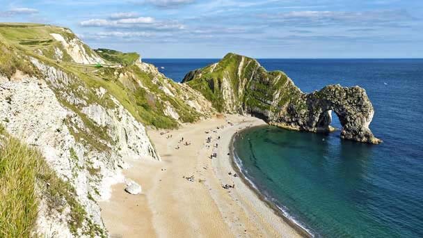 Aerial view of Dorset beach near Weymouth showing the white cliffs yellow sand sea and cliff arch