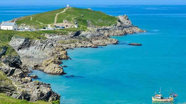 Image showing headlands in Newquay with rocky cliffs and a boat in view in the sea