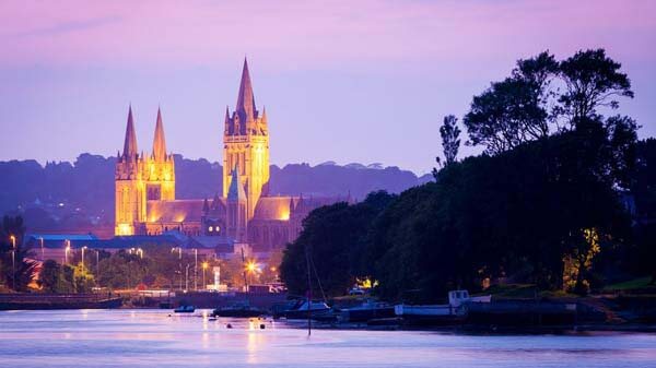 A view of Truro town across the water showing cathedral lights