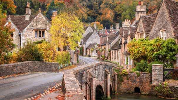 Image of a small Wiltshire town showing a bridge over a river with cottages.