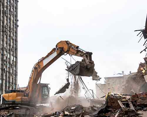 360 Excavator shown demolishing a building and clearing rubble