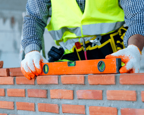Two construction managers on a building site holding construction planning documents